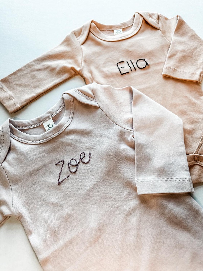 Two Colored Organics Long Sleeve Bodysuits with the names Zoe and Ella Hand Stitched.