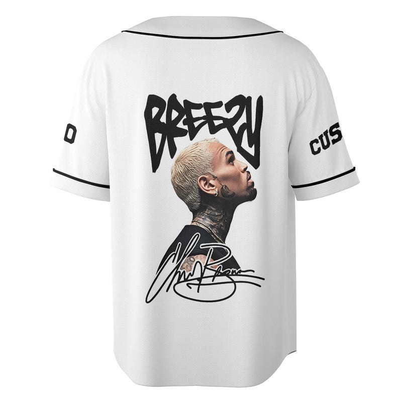 May include: White baseball jersey with black trim and the word "Breezy" in a black, stylized font on the back. A portrait of a person with blonde hair and tattoos is featured below the text, along with a signature.
