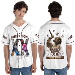 May include: White baseball jersey with brown trim. The front features "BREEZY BOWL XX" text and graphics. The back displays a sepia-toned image of a person, stars, and text. Sleeves have "TOM" and "CUS" text.