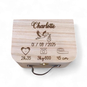 Peut inclure: Un coffret souvenir en bois clair avec le nom "Charlotte" gravé sur le couvercle, ainsi qu'une cigogne portant un bébé. Le coffret comprend des détails gravés : date, heure, poids (3,6 kg) et longueur (45 cm).