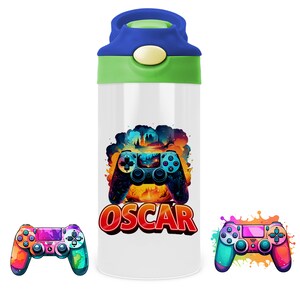 Peut inclure: Une bouteille d'eau blanche avec un couvercle vert et un bouchon bleu. La bouteille présente un graphisme coloré d'une manette de jeu vidéo avec le nom "OSCAR" imprimé en dessous. Deux autres manettes de jeu vidéo colorées sont représentées de chaque côté de la bouteille.