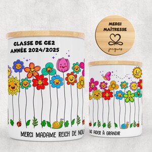 Peut inclure: Deux bocaux en céramique blanche avec des couvercles en bois, décorés de fleurs de dessins animés colorées, de coccinelles et d'escargots. Le grand bocal porte l'inscription "CLASSE DE CE2 ANNÉE 2024/2025" et "MERCI MADAME REICH DE NOU". Un couvercle en bois avec "MERCI MAÎTRESSE" et un cœur est également visible.