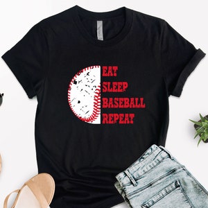 May include: Black t-shirt with a white baseball graphic and the text "Eat Sleep Baseball Repeat" in white.