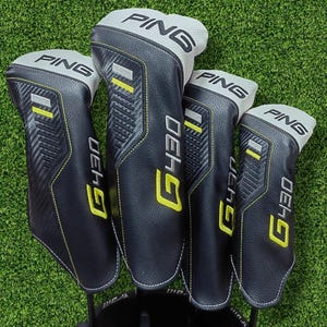 May include: A set of four black and grey golf club head covers featuring the PING logo and G430 text in yellow. The covers have a textured finish with yellow stitching accents and are designed to protect golf clubs during transport and storage.