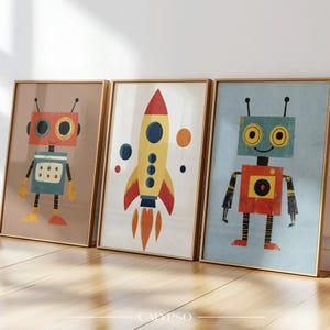 May include: Three framed art prints featuring a robot, a rocket, and another robot. The robot prints have red, blue, and yellow details. The rocket print is yellow with red and blue accents. The frames are gold-colored.