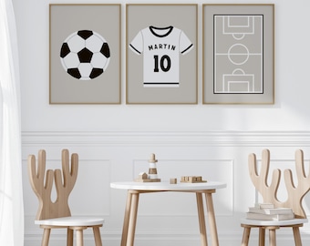 May include: Three framed prints with a gray background and black illustrations. The prints feature a soccer ball, a soccer jersey with the name "Martin" and the number "10", and a soccer field.