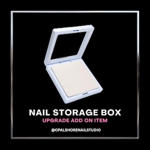 May include: A white, square nail storage box with a clear lid, open to reveal a beige interior. The text "NAIL STORAGE BOX" and "UPGRADE ADD ON ITEM" are displayed below the box on a black background.