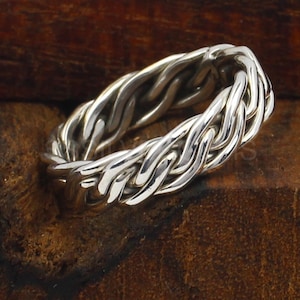 Peut inclure: Une bague en argent tressée avec une finition lisse et polie. La bague est faite d'une bande épaisse et tressée.