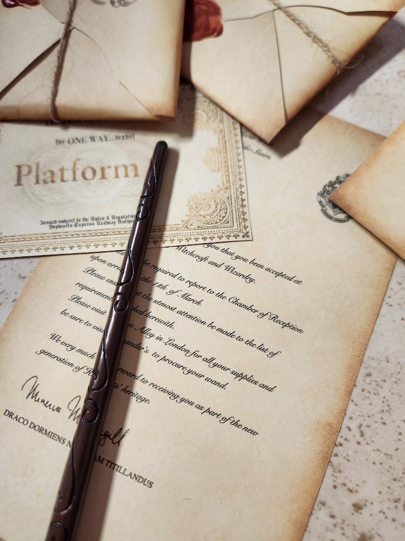 May include: A brown wooden wand with intricate carvings. The wand is lying on a piece of parchment paper with text that reads "Witchcraft and Wizardry" and "You that you been accepted at".