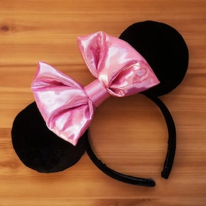 May include: Black velvet mouse ears headband with a pink sparkly bow.