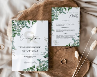 May include: Wedding invitation suite featuring a main invitation card and a details card. Both cards have a white background with green eucalyptus and floral accents. The main card includes the names "Carrie & Karim" and wedding details. A gold ring and dried flowers are also present.