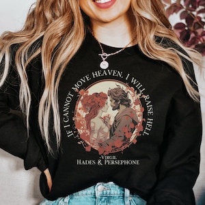 K&ouml;nnte beinhalten: Schwarzes Sweatshirt mit einem Grafikdruck von Hades und Persephone. Der Druck zeigt ein Zitat von Virgil: "Wenn ich den Himmel nicht bewegen kann, werde ich die H&ouml;lle entfachen."