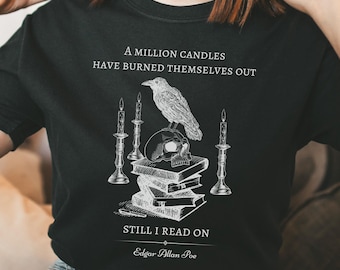 May include: Black t-shirt with a white graphic design featuring a skull, a raven, and candles on top of a stack of books. The text reads "A million candles have burned themselves out, still I read on, Edgar Allan Poe."