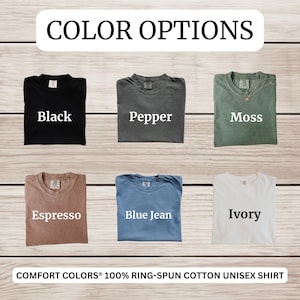 May include: Image showcasing six t-shirt color options: Black, Pepper, Moss, Espresso, Blue Jean, and Ivory. The text "COLOR OPTIONS" is at the top, and "COMFORT COLORS&reg; 100% RING-SPUN COTTON UNISEX SHIRT" is at the bottom. The shirts are displayed on a wooden background.