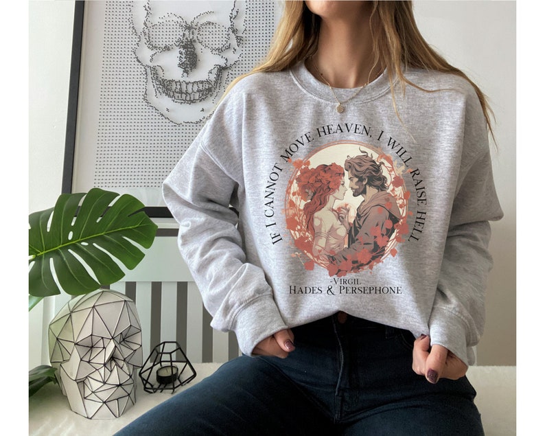 K&ouml;nnte beinhalten: Grauer Pullover mit einem Grafikdruck eines Paares in einem Kreis mit dem Text "Wenn ich den Himmel nicht bewegen kann, werde ich die H&ouml;lle erwecken - Virgil Hades & Persephone"