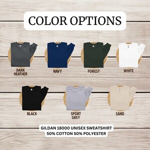 May include: Color options for a Gildan 18000 unisex sweatshirt. The sweatshirt is available in dark heather, navy, forest, white, black, sport grey, and sand.