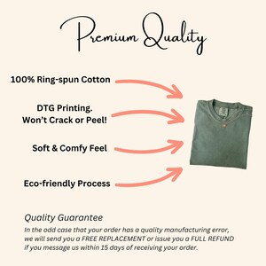 Op de afbeelding: Een opgevouwen saliegroen t-shirt met een gouden ketting wordt getoond op een cr&egrave;mekleurige achtergrond. Tekst bevat "Premium Quality", "100% Ring-spun Cotton", "DTG Printing. Won't Crack or Peel!", "Soft & Comfy Feel" en "Eco-friendly Process".
