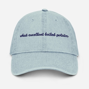 May include: Light blue denim baseball cap with the embroidered text "what excellent boiled potatoes" in navy blue. The cap has a curved brim and a six-panel design, suitable for casual wear.
