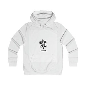 Puede incluir: Sudadera con capucha blanca con un gráfico negro de una flor con la palabra "paz" debajo.