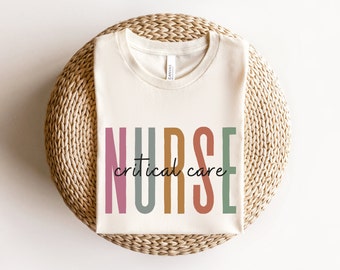 May include: A white t-shirt with the word "NURSE" in colorful letters and the words "critical care" written below.
