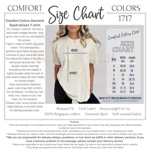 Op de afbeelding: Een Comfort Colors 1717 unisex t-shirt maattabel met een cr&egrave;mekleurig t-shirt met korte mouwen. De tabel toont breedte- en lengtematen in inches voor de maten S tot 4XL, vari&euml;rend van 18,25 tot 29,75 inch breed en 26,6 tot 33,5 inch lang.