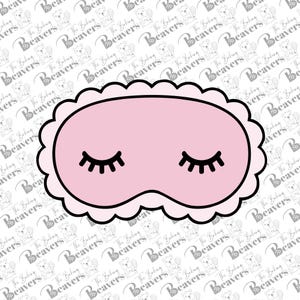 May include: A pink sleep mask with a black outline and scalloped edges. The mask features closed eyes with black eyelashes. The background has a repeating pattern of a beaver logo and the words "The Baking Beavers".