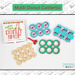 May include: A collection of donut-making tools and a box from the North Pole Donut Shop. The image features a box, donut cutters in teal and green, a red plunger, and several cut-out donuts. The text "Multi Donut Cutter(s)" is at the top.