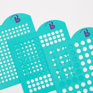 May include: Three turquoise blue stencils with different sized circles cut out. The stencils have a rounded top with a purple logo that says "Beads & Beyond".