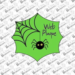 May include: A bright green, six-pointed plaque featuring a black spider web design in the upper left corner and a black spider with yellow eyes hanging from a thread. The text Web Plaque is printed in purple on the right side of the green surface.
