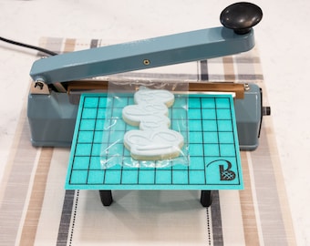 Heat seal table with removable legs and storage compartment