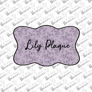 May include: A light purple plaque with a decorative floral pattern and the words "Lily Plaque" in black script. The plaque has a wavy border and is set against a white background with a repeating pattern.