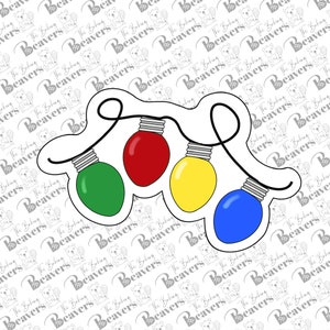 May include: A string of four Christmas lights in red, green, yellow, and blue. The lights are connected by a black wire and are hanging from a white background.