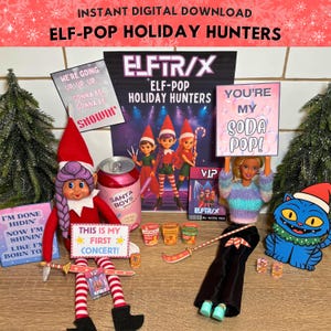 May include: A Christmas-themed display featuring an elf doll, a Barbie doll, and a blue cat, alongside props like a soda can and signs. The scene is set against a backdrop of Christmas trees and snowflakes, with the text 'ELF-POP HOLIDAY HUNTERS'.