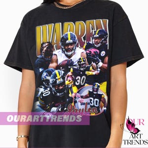 May include: Black t-shirt featuring a collage of football players in action, with the name "WARREN" in large yellow letters at the top. The shirt includes the text "Ste Jaylen" and the brand name "OURARTTRENDS".