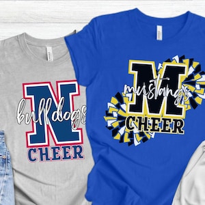 May include: Two t-shirts, one gray and one blue, with cheerleading designs. The gray shirt features a large letter "N" with "bulldogs" and "CHEER" text. The blue shirt displays "Mustangs CHEER" with pom-pom graphics.