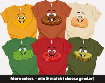 May include: A collection of colorful t-shirts featuring cartoon food characters. The shirts include a yellow cheese slice, a brown burger patty, a beige burger bun, green lettuce, a red tomato slice, and a green pickle. The text "More colors - mix & match (choose gender)" is at the bottom.