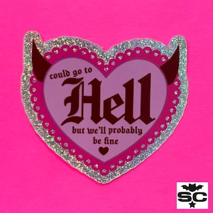 May include: A pink heart-shaped sticker with a silver glitter border. The sticker has devil horns and says "could go to Hell but we'll probably be fine".