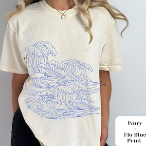 May include: Ivory t-shirt with a blue wave print. The text "Ivory + Flo Blue Print" is on a white tag.