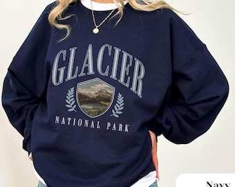 May include: Navy blue sweatshirt with a graphic print of a mountain scene and the text "Glacier National Park".