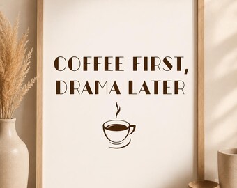 May include: A rectangular wall art print in a light wood frame featuring the dark brown text COFFEE FIRST, DRAMA LATER centered above a simple line drawing of a steaming coffee cup and saucer on a white background.