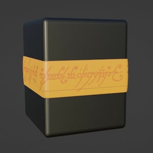 May include: A black box with a gold band around it. The band has the inscription "One Ring to rule them all, One Ring to find them, One Ring to bring them all and in the darkness bind them." in an orange font.