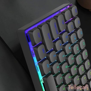 Puede incluir: Un teclado mecánico compacto con teclas negro mate, letras azules y una vibrante retroiluminación LED en tonos morado y azul. La disposición del teclado incluye teclas de función estándar, una tecla de mayúsculas y teclas de control, con la marca Tellocafi visible.