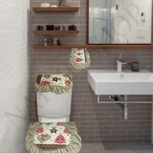 May include: A Christmas-themed toilet seat cover set. The set includes a toilet seat cover, a tank cover, and a toilet seat lid cover. Each piece features a cream-colored background with red and green Christmas tree and star patterns, trimmed with a ruffled edge.