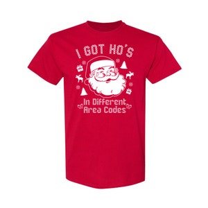 May include: Red t-shirt with a white graphic of Santa Claus with the text "I got ho's in different area codes".