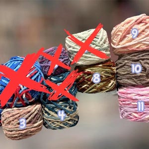 May include: A collection of colorful yarn balls, each with a unique color scheme. The yarn balls are numbered, with shades of brown, pink, and blue. Ideal for knitting and crochet projects.