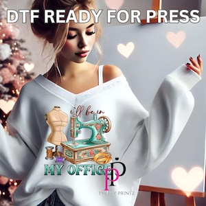 May include: A white sweatshirt with a graphic of a sewing machine and the text "I'll be in my office" with a pink "P" for Pretty Printz.