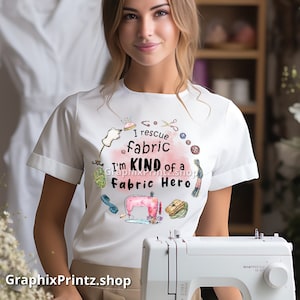 May include: White t-shirt with a pink and white watercolor design featuring sewing tools and the text "I rescue fabric I'm kind of a fabric hero".