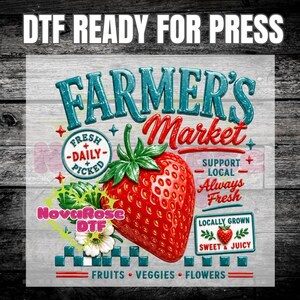 May include: A DTF transfer design featuring a large red strawberry with green leaves. Text includes FARMER'S Market, FRESH DAILY PICKED, SUPPORT LOCAL ALWAYS FRESH, LOCALLY GROWN SWEET & JUICY, FRUITS VEGGIES FLOWERS, and NovaRose DTF.