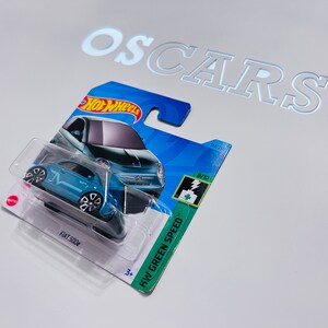Voiture moulée sous pression verte Fiat 500e HotWheels. Carte courte.