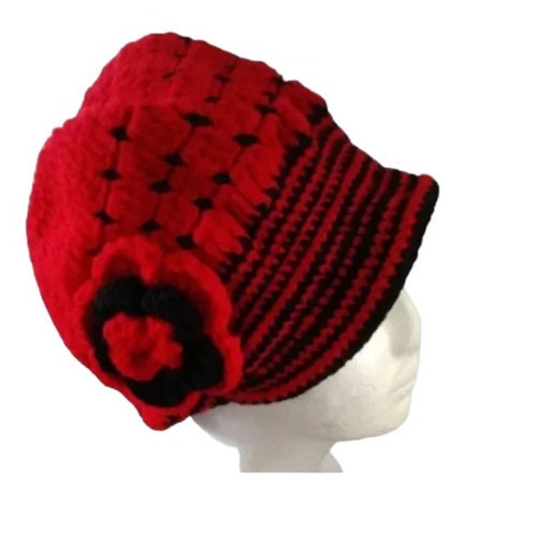 Handmade winter hat with red and black crochet flowers and yarn.